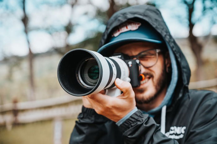 Man using a Sony camera with telephoto lens
