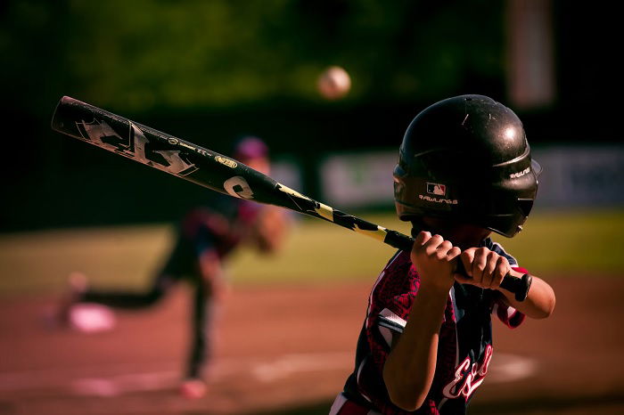 Rear view of young baseball player about to hit the ball