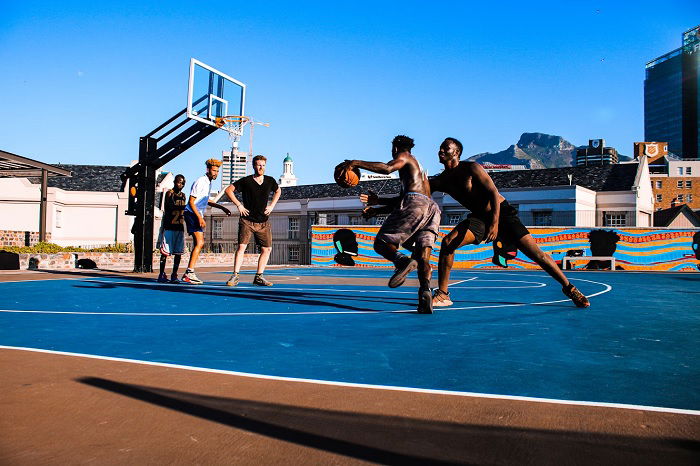 Young men playing backetball on an outside court